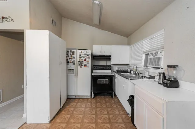 a kitchen with refrigerator and cabinets