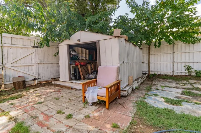 a view of a backyard with a small cabin and a chair