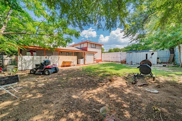 a view of a house with backyard and a tree