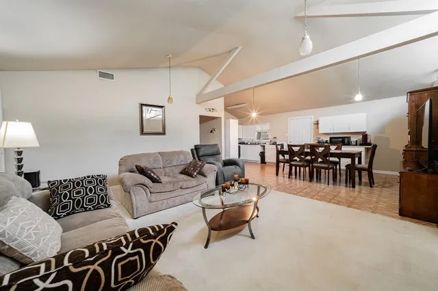 a living room with furniture and kitchen view