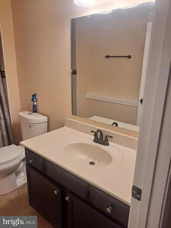 a bathroom with a sink and mirror with toilet