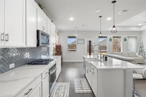 a kitchen with stainless steel appliances a sink stove and cabinets