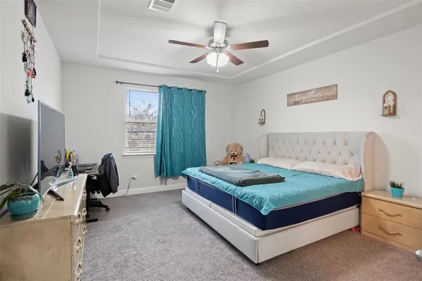 a bedroom with a bed and a flat tv screen on the dresser