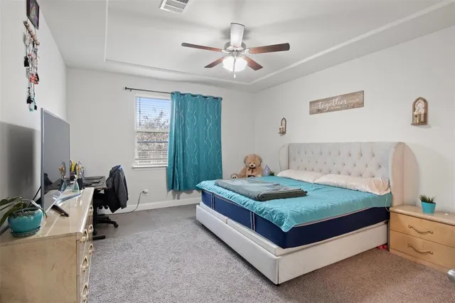 a bedroom with a bed and a flat tv screen on the dresser