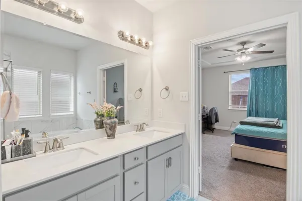 a spacious en suite bathroom with double sink and a mirror