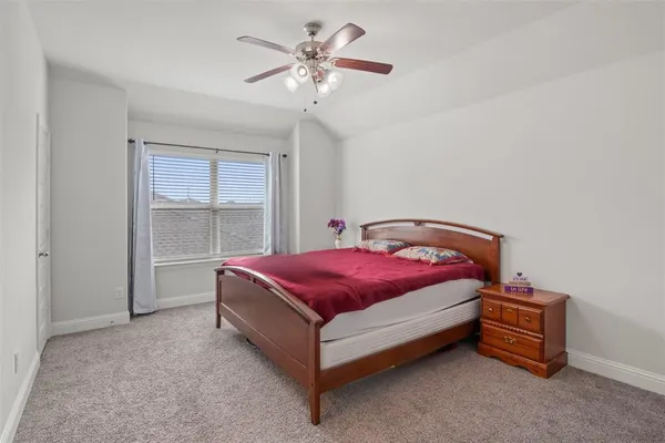 a spacious bedroom with a bed and a chandelier