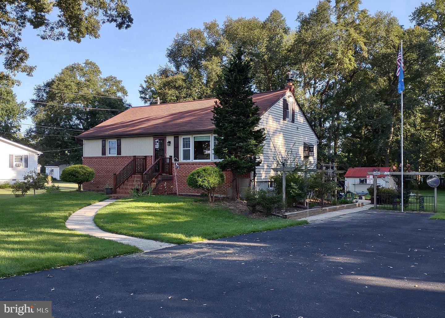 a front view of a house with a garden and trees