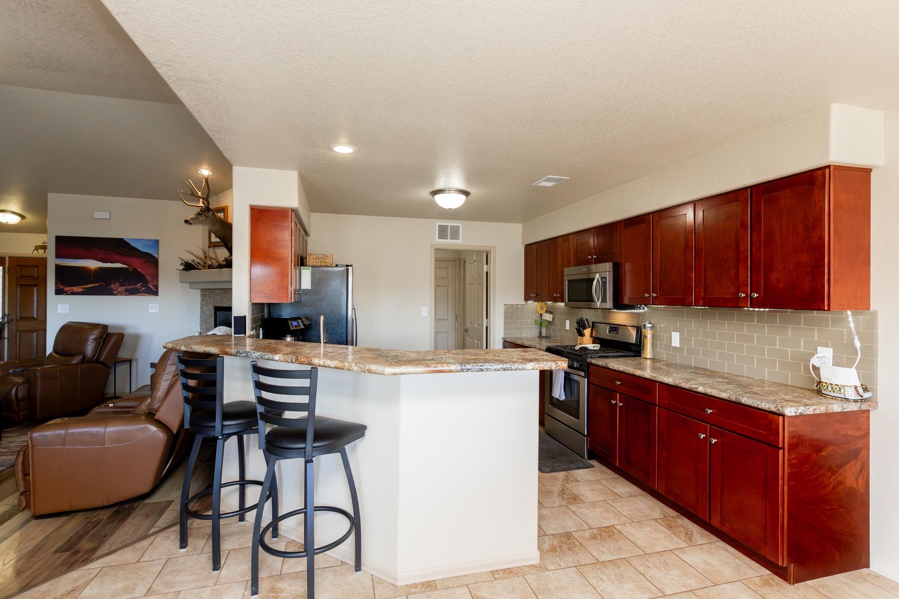 103 Red Rocks Street Fruita, CO 81521 - Photo 24 of 39 a kitchen with kitchen island granite countertop wooden cabinets and stainless steel appliances