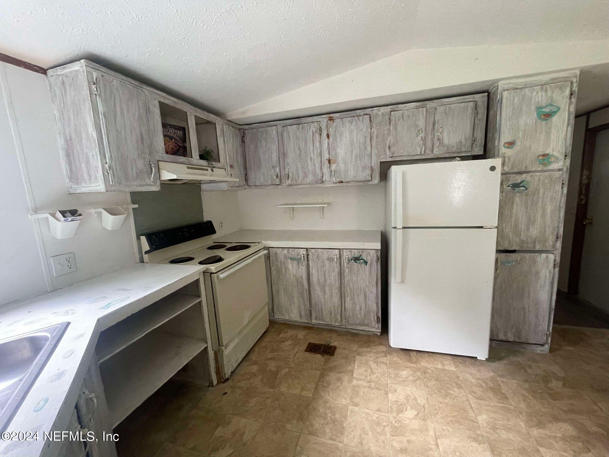 12550 Southeast 55th Place Starke, FL 32091 - Photo 11 of 29 a kitchen with a refrigerator sink and microwave