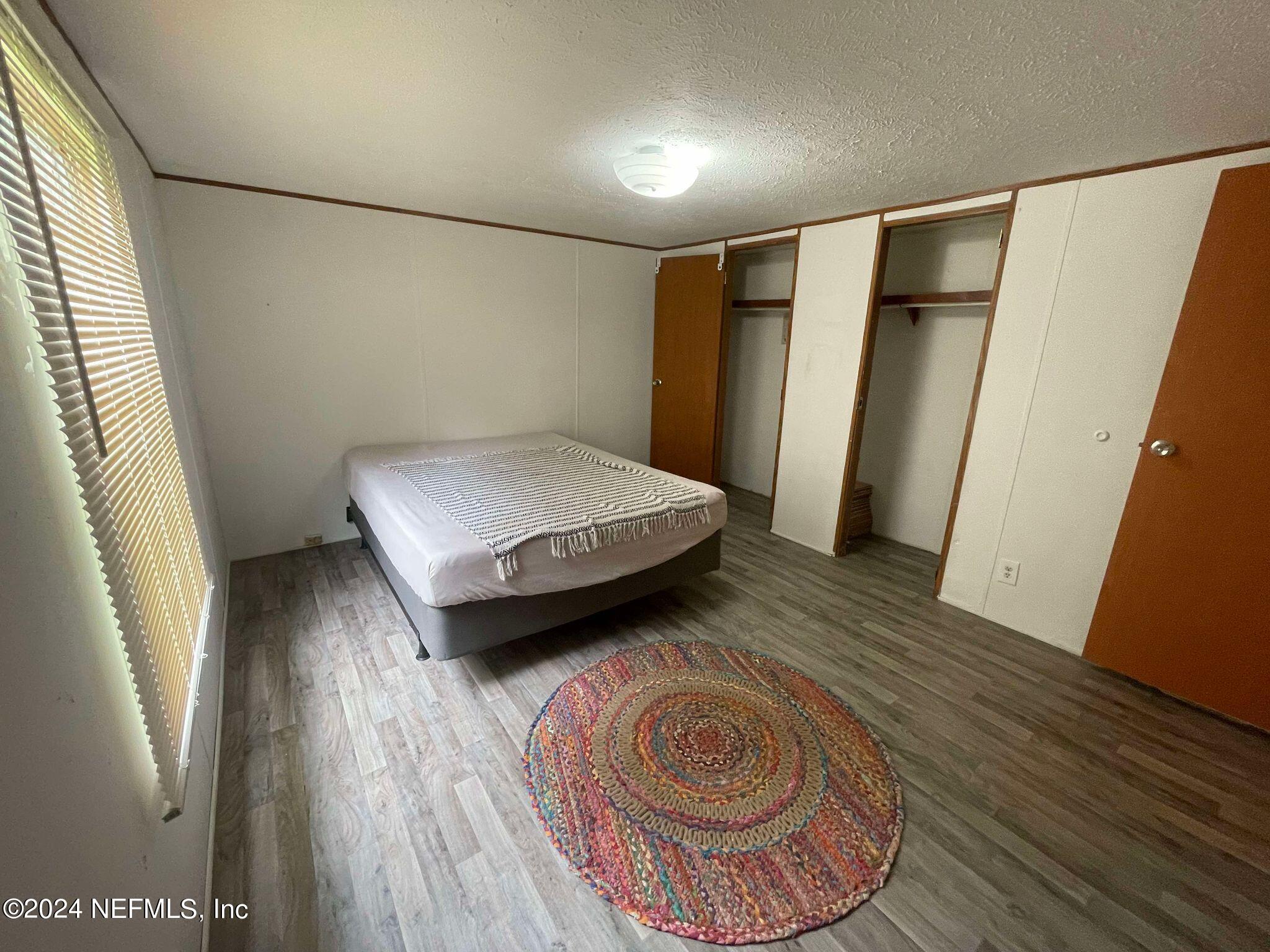 12550 Southeast 55th Place Starke, FL 32091 - Photo 13 of 29 a bedroom with a bed and a mirror