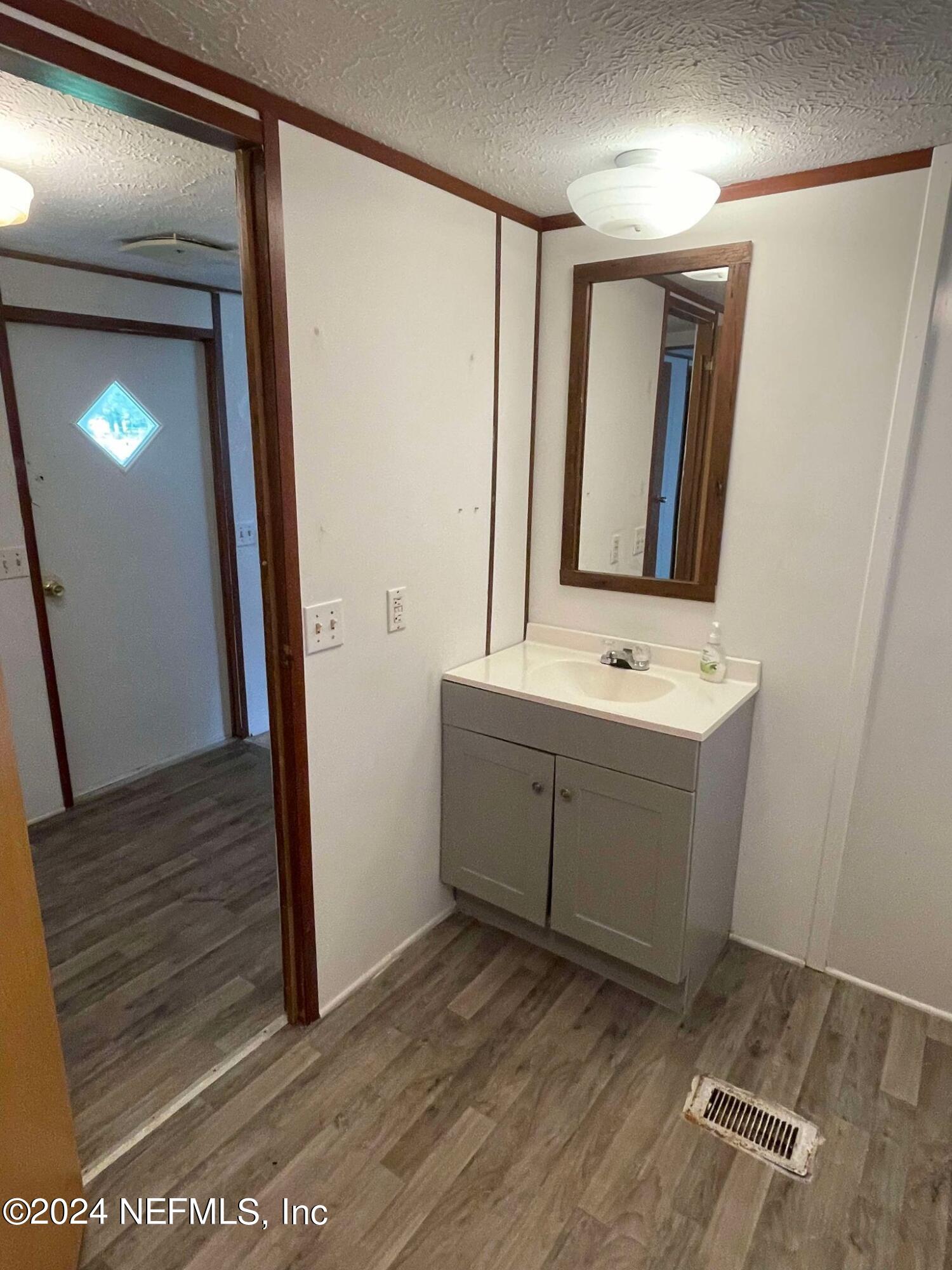 12550 Southeast 55th Place Starke, FL 32091 - Photo 18 of 29 a bathroom with a sink a mirror and a vanity