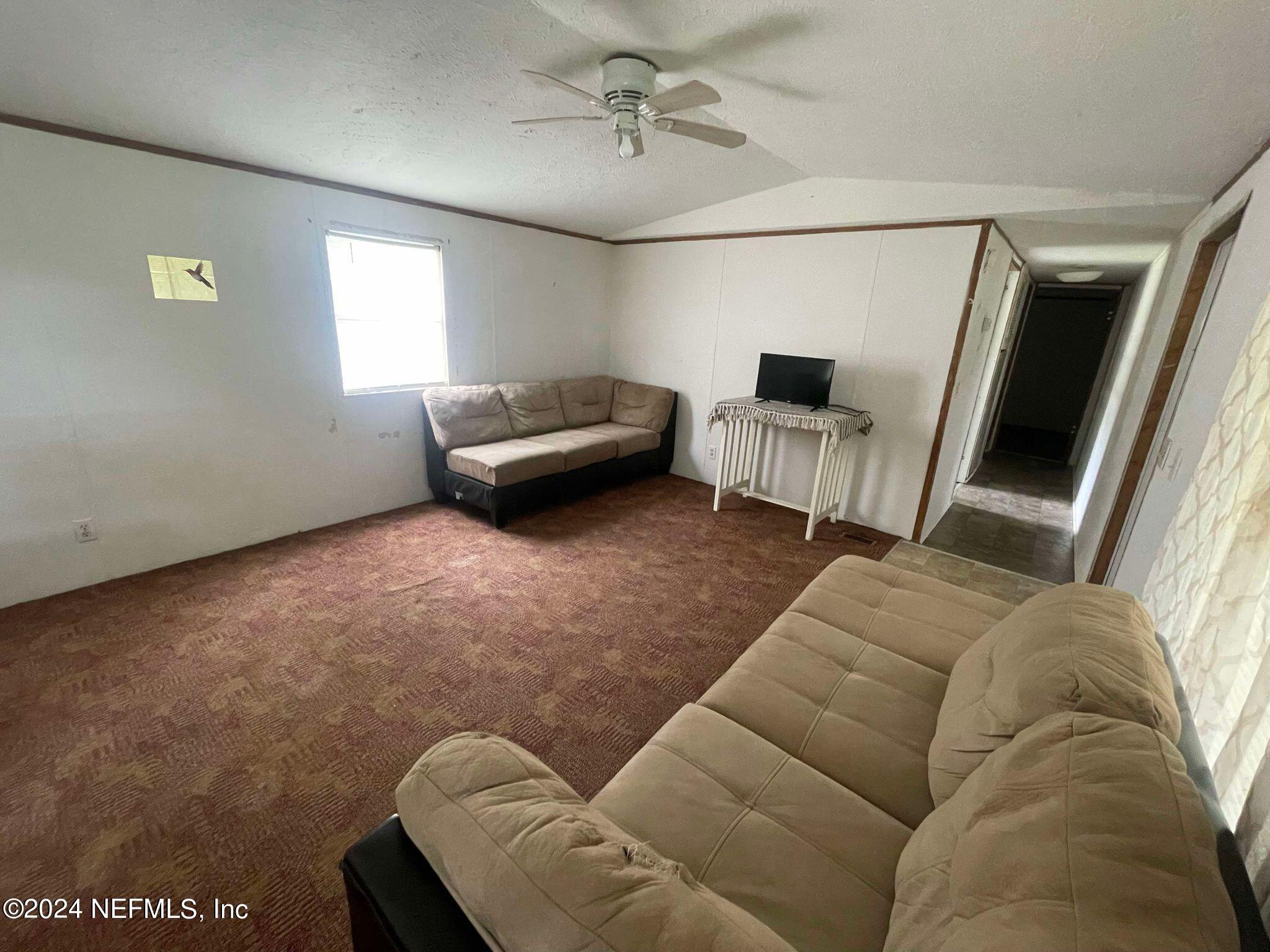 12550 Southeast 55th Place Starke, FL 32091 - Photo 22 of 29 a living room with furniture and a flat screen tv