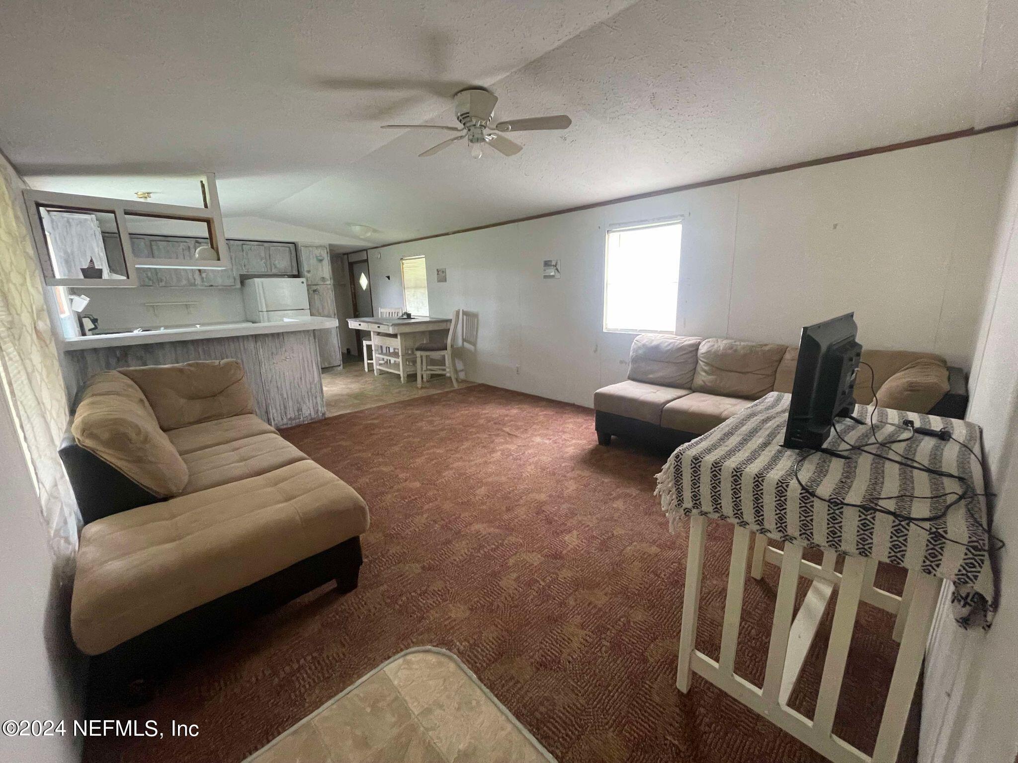 12550 Southeast 55th Place Starke, FL 32091 - Photo 4 of 29 a living room with furniture and a ceiling fan