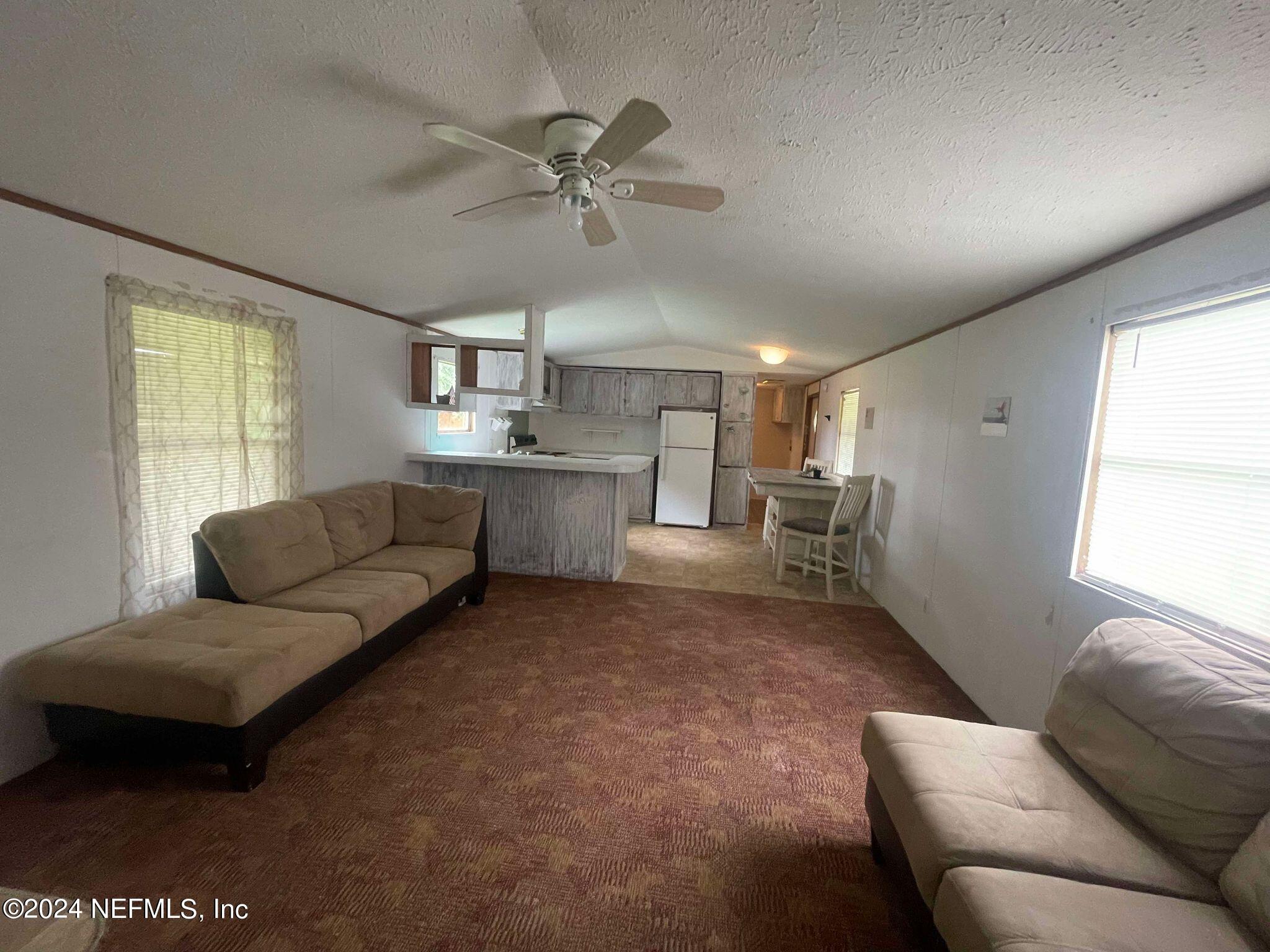 12550 Southeast 55th Place Starke, FL 32091 - Photo 5 of 29 a living room with furniture and a chandelier