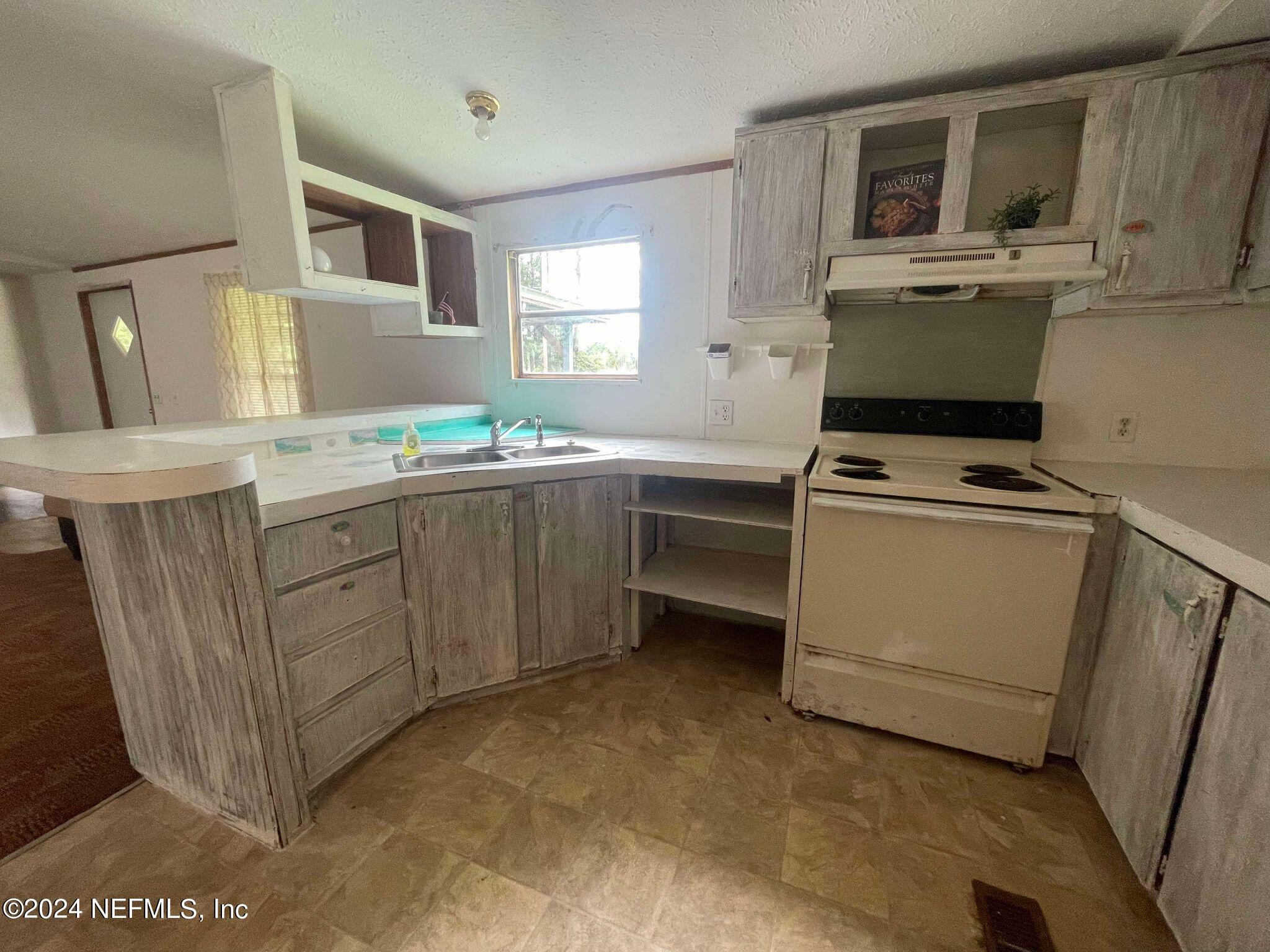12550 Southeast 55th Place Starke, FL 32091 - Photo 9 of 29 a kitchen with a stove top oven sink and cabinets
