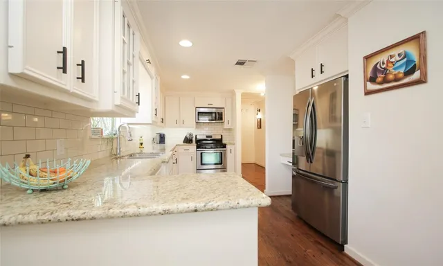 a kitchen with granite countertop a refrigerator and a sink