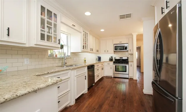 a kitchen with stainless steel appliances a refrigerator sink and cabinets