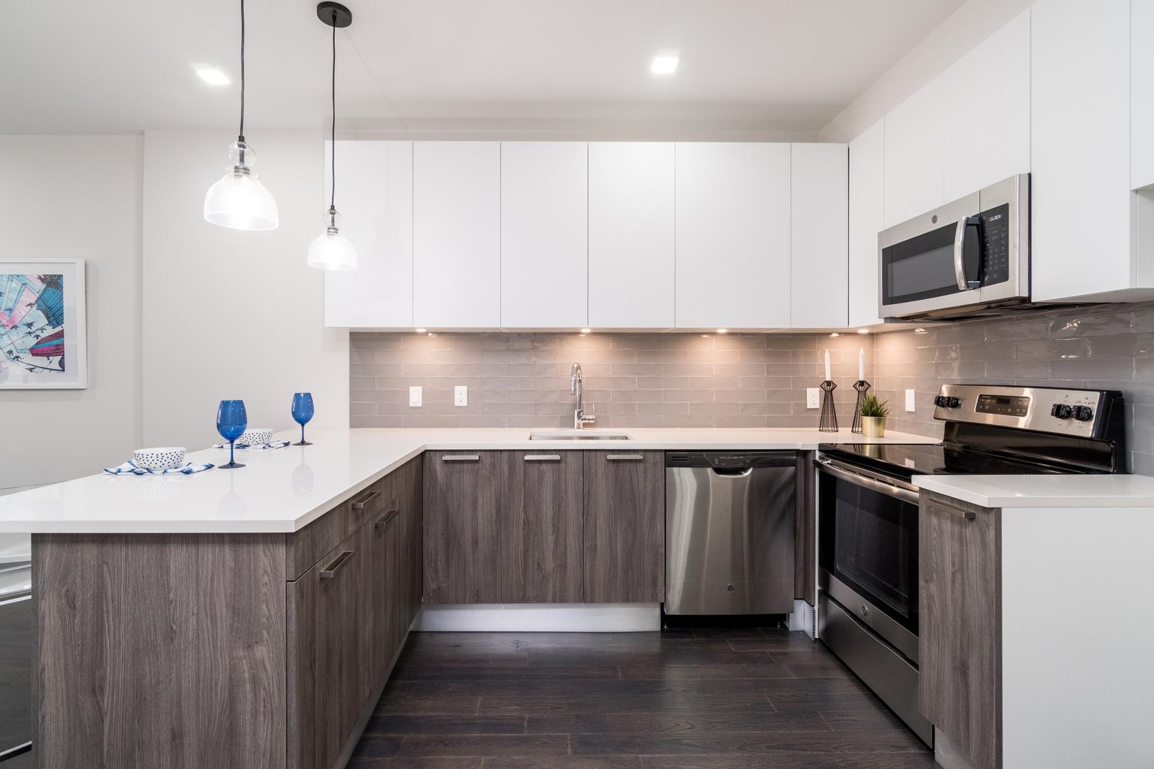 6122 Hudson Avenue, Unit 5A West New York, NJ 07093 - Photo 6 of 29 a kitchen with stainless steel appliances a sink a stove a microwave and wooden cabinets