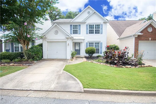 a front view of a house with a yard and garage
