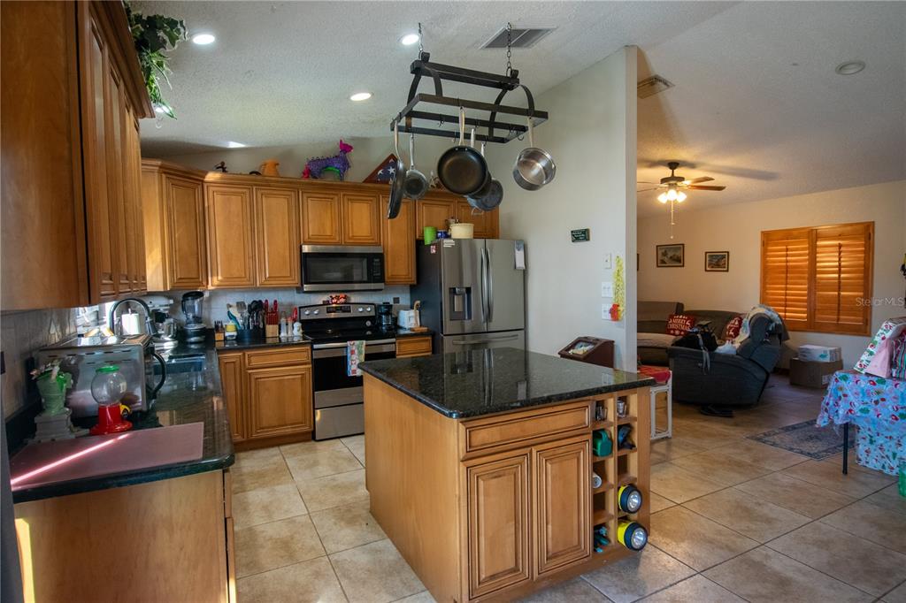6219 Coliseum Boulevard Port Charlotte, FL 33981 - Photo 13 of 48 a kitchen with stainless steel appliances granite countertop a sink a stove and a microwave