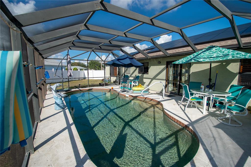 6219 Coliseum Boulevard Port Charlotte, FL 33981 - Photo 35 of 48 a view of a patio with table and chairs under an umbrella