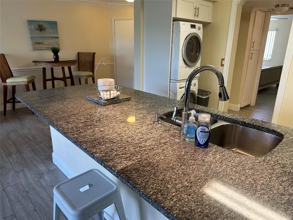 a kitchen with a sink and a stove with wooden floor