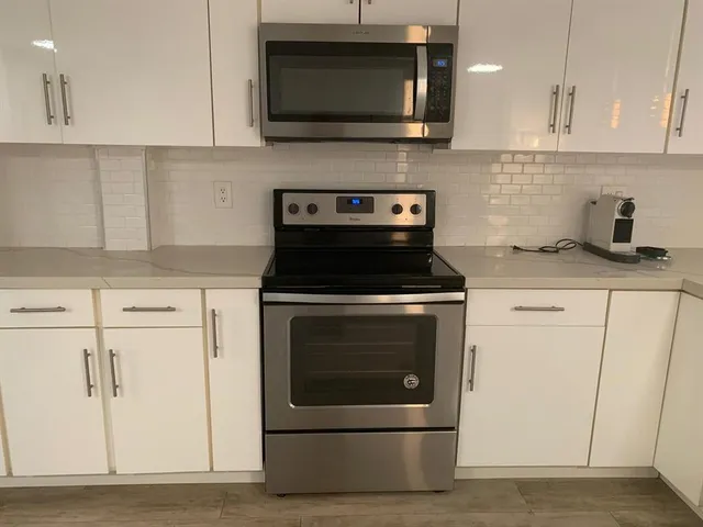 a kitchen with stainless steel appliances granite countertop a stove a microwave and a refrigerator