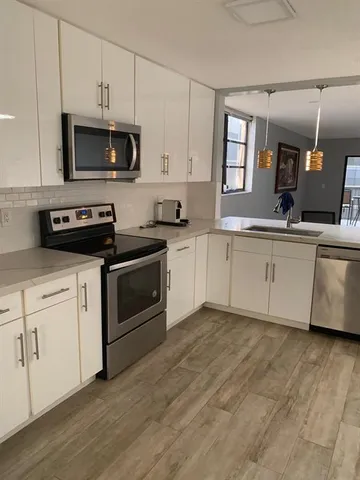 a kitchen with granite countertop a stove a sink and a microwave