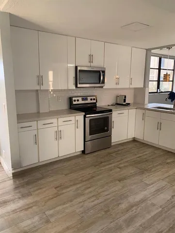 a kitchen with cabinets a sink and appliances