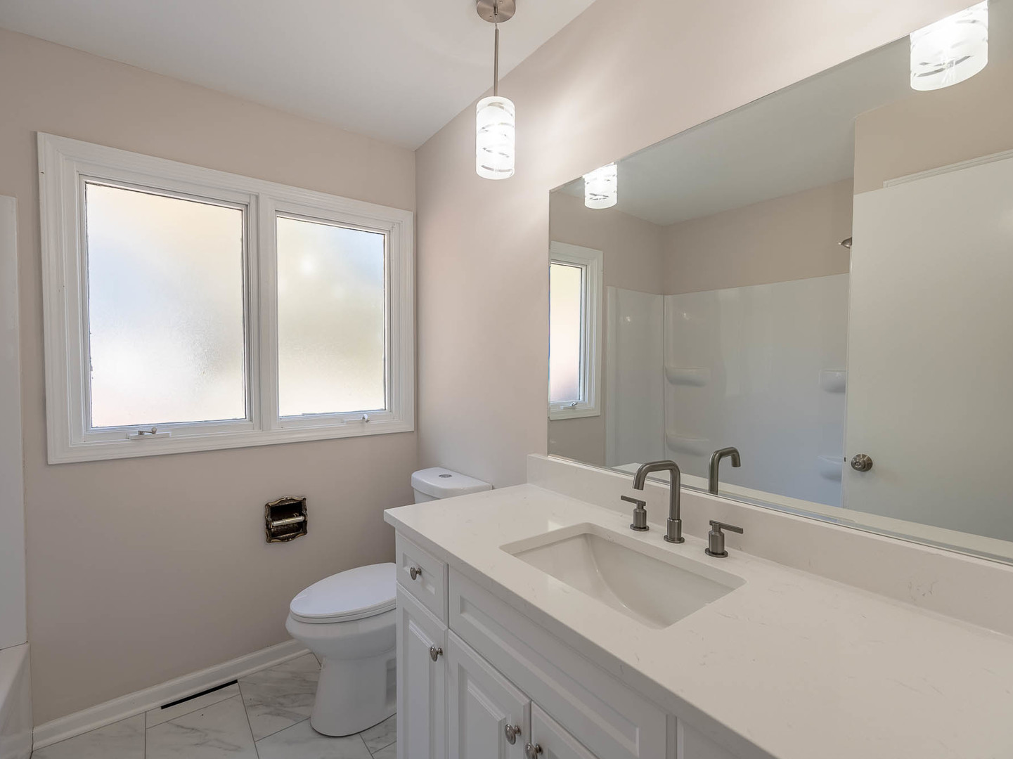 7104 Blackburn Avenue Downers Grove, IL 60516 - Photo 11 of 17 a bathroom with a toilet a sink a mirror and a window