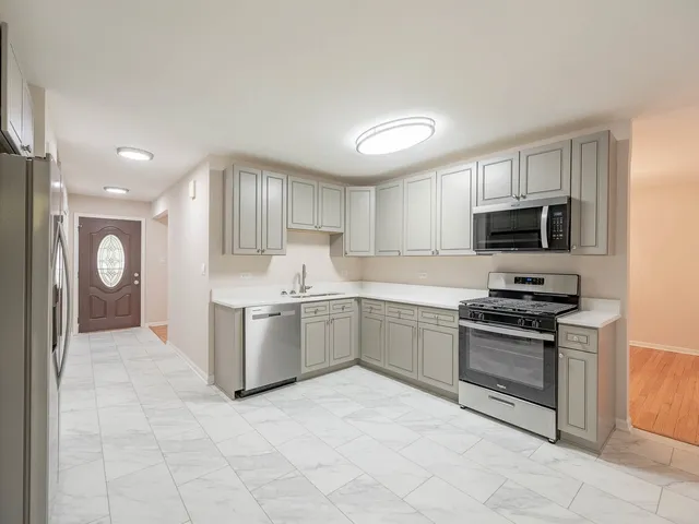a kitchen with a stove top oven and cabinets