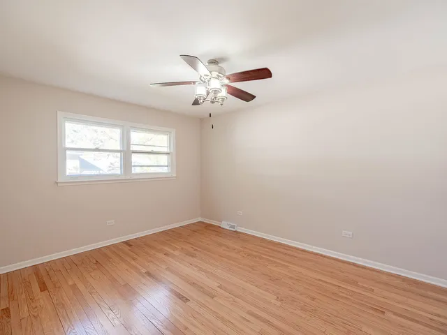 a view of a room with wooden floor and a ceiling fan