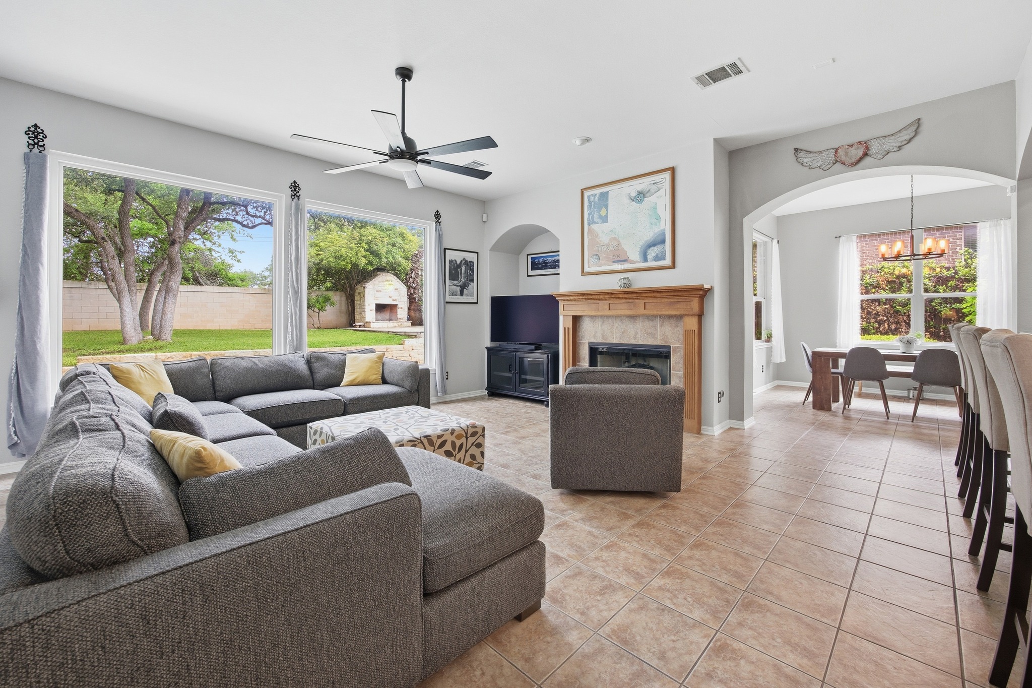 2204 Rio Mesa Drive Austin, TX 78732 - Photo 11 of 40 Spacious living area featuring large windows that provide views of the backyard, a ceiling fan, and tile flooring