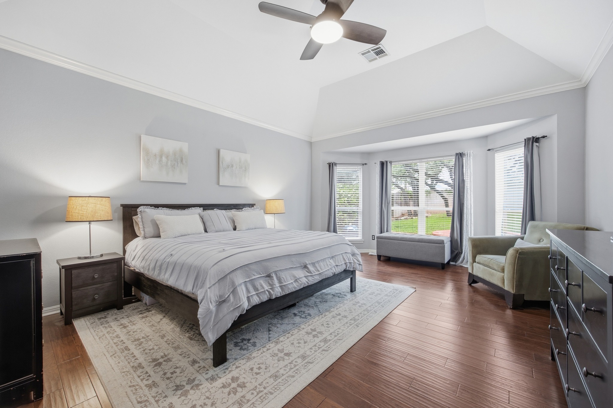 2204 Rio Mesa Drive Austin, TX 78732 - Photo 21 of 40 The bedroom features hardwood floors, a tray ceiling with a ceiling fan, and a large bay window with views of the backyard
