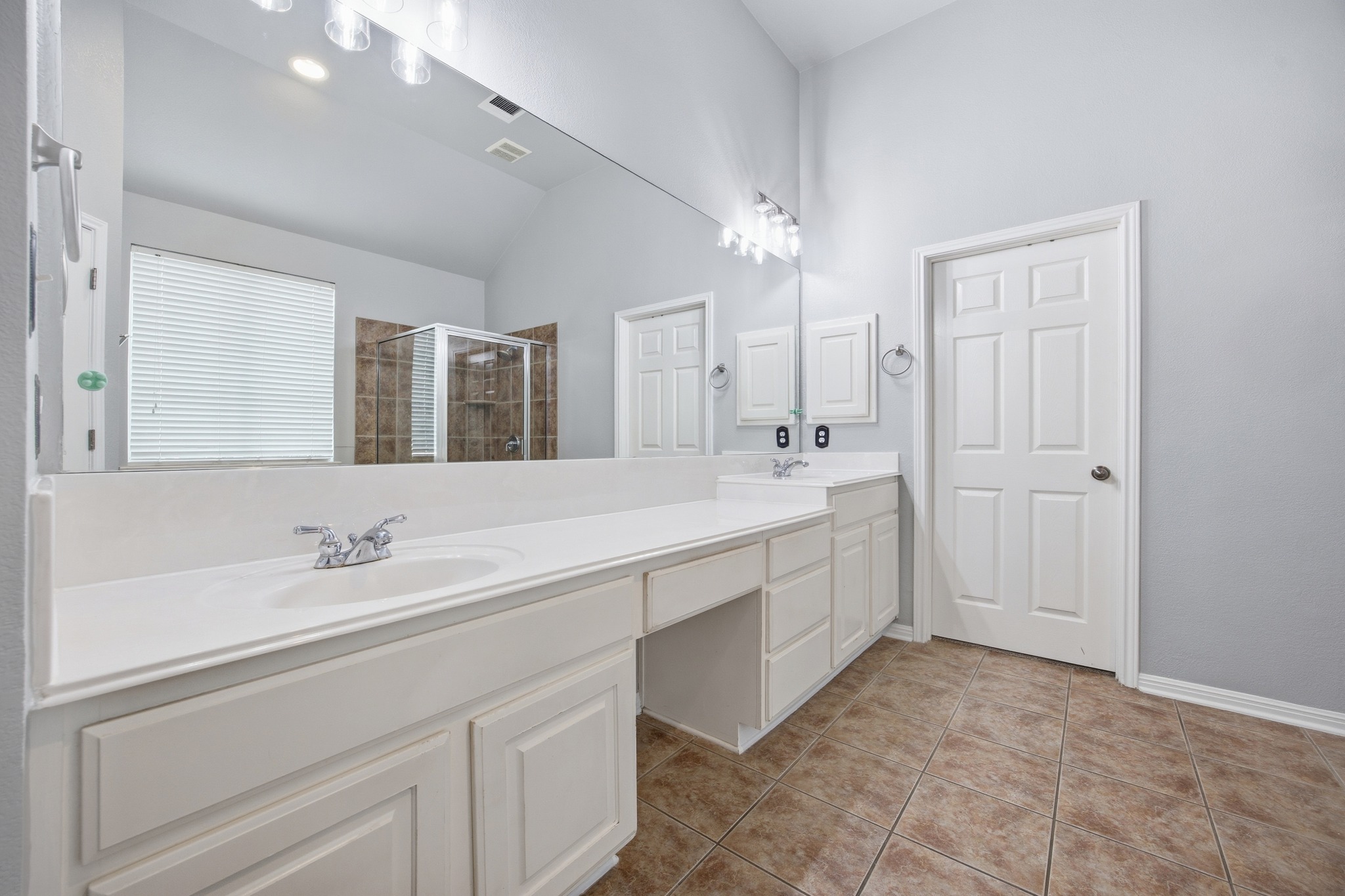 2204 Rio Mesa Drive Austin, TX 78732 - Photo 23 of 40 The bathroom features a double vanity with white cabinetry, a large mirror, and tiled flooring