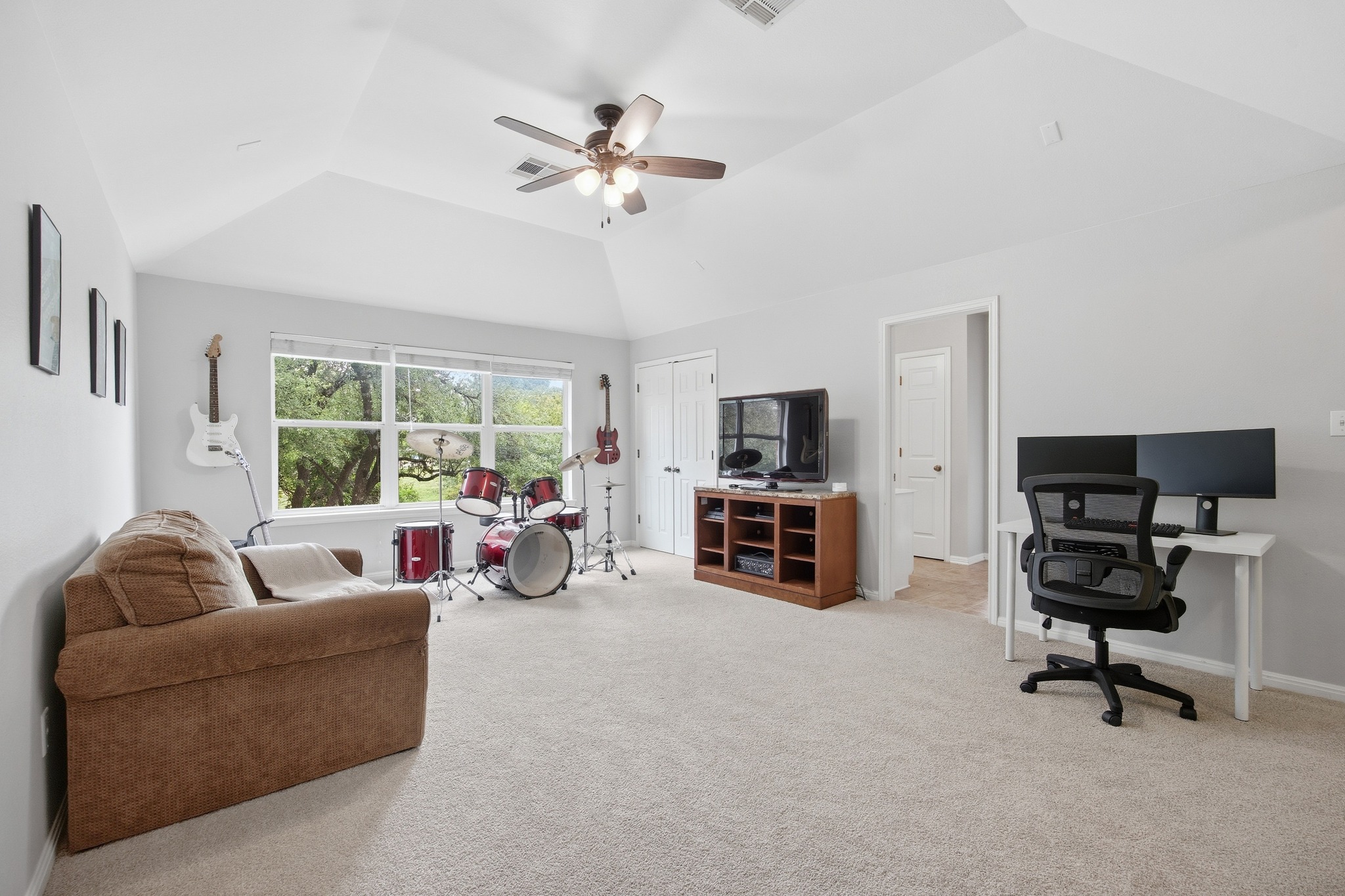 2204 Rio Mesa Drive Austin, TX 78732 - Photo 25 of 40 Spacious room featuring vaulted ceilings, light-colored carpeting, and a large window providing views of greenery