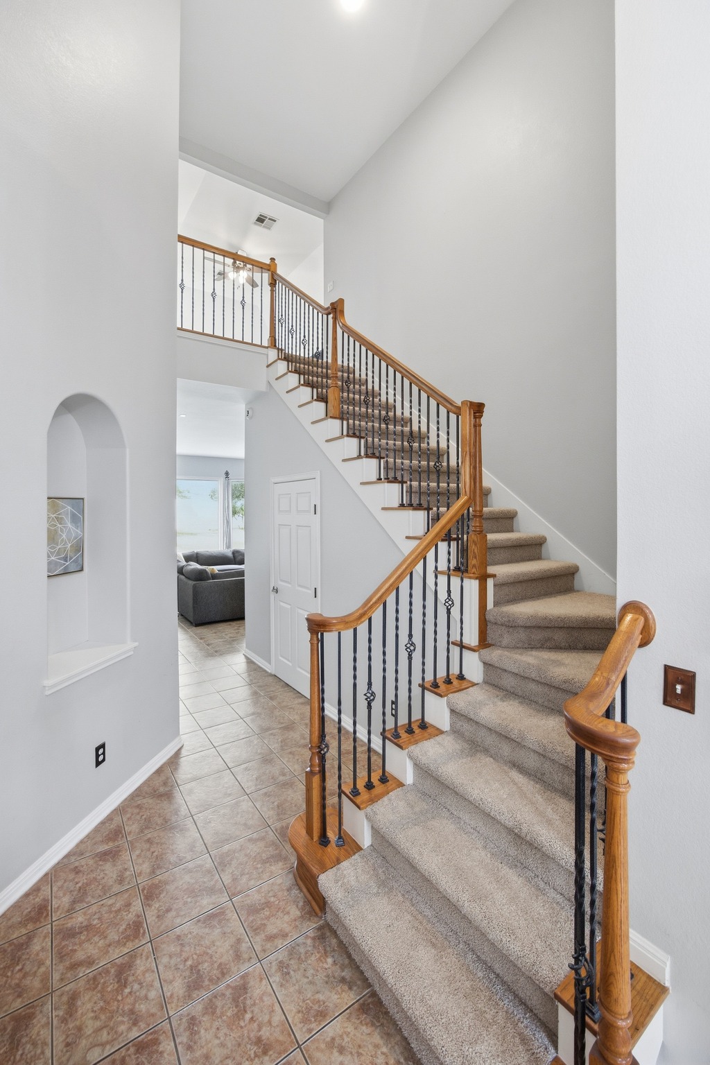 2204 Rio Mesa Drive Austin, TX 78732 - Photo 5 of 40 The property features a staircase with carpeted treads and risers, wood handrails, and decorative black metal balusters