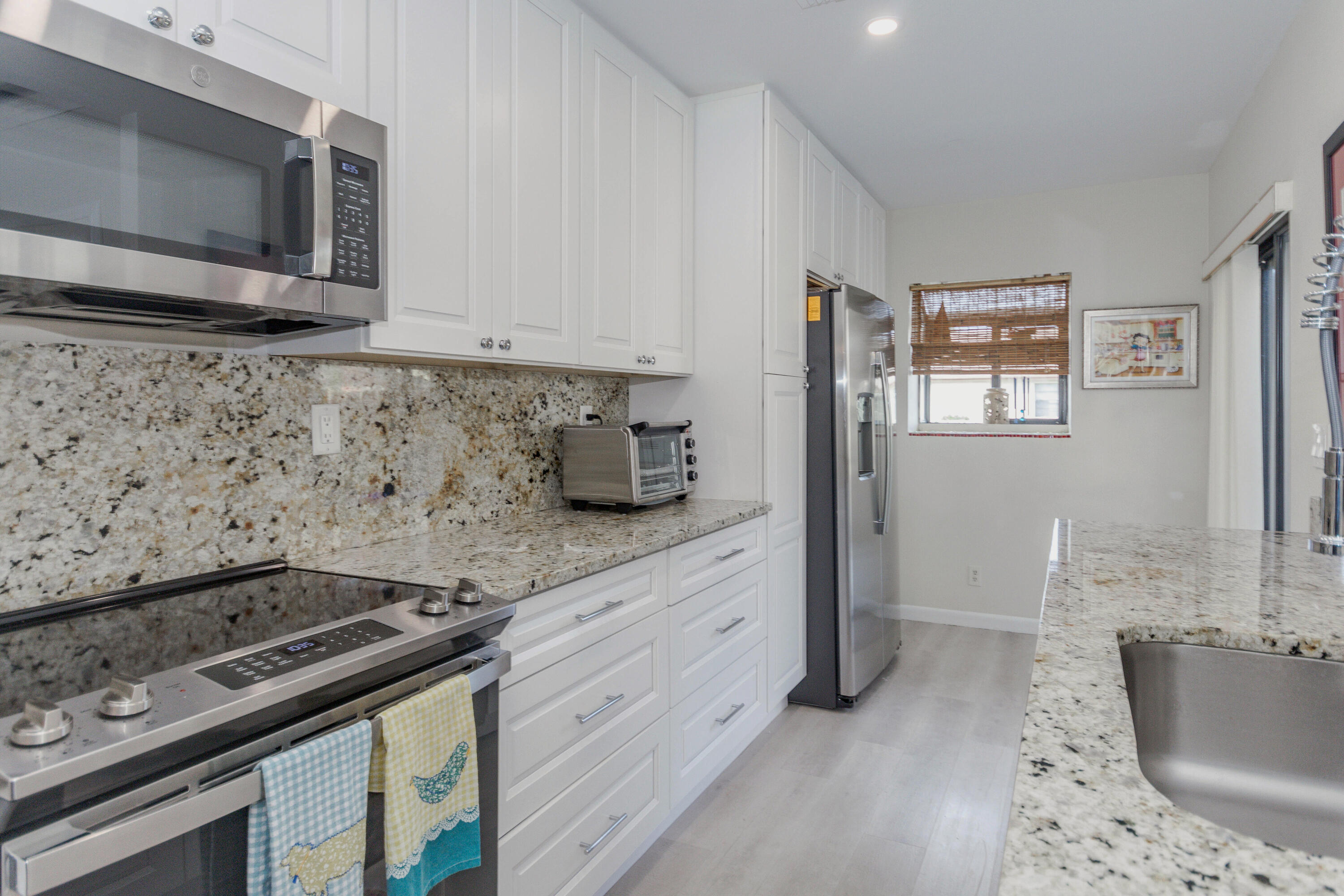 a kitchen with stainless steel appliances granite countertop a stove a microwave and a sink