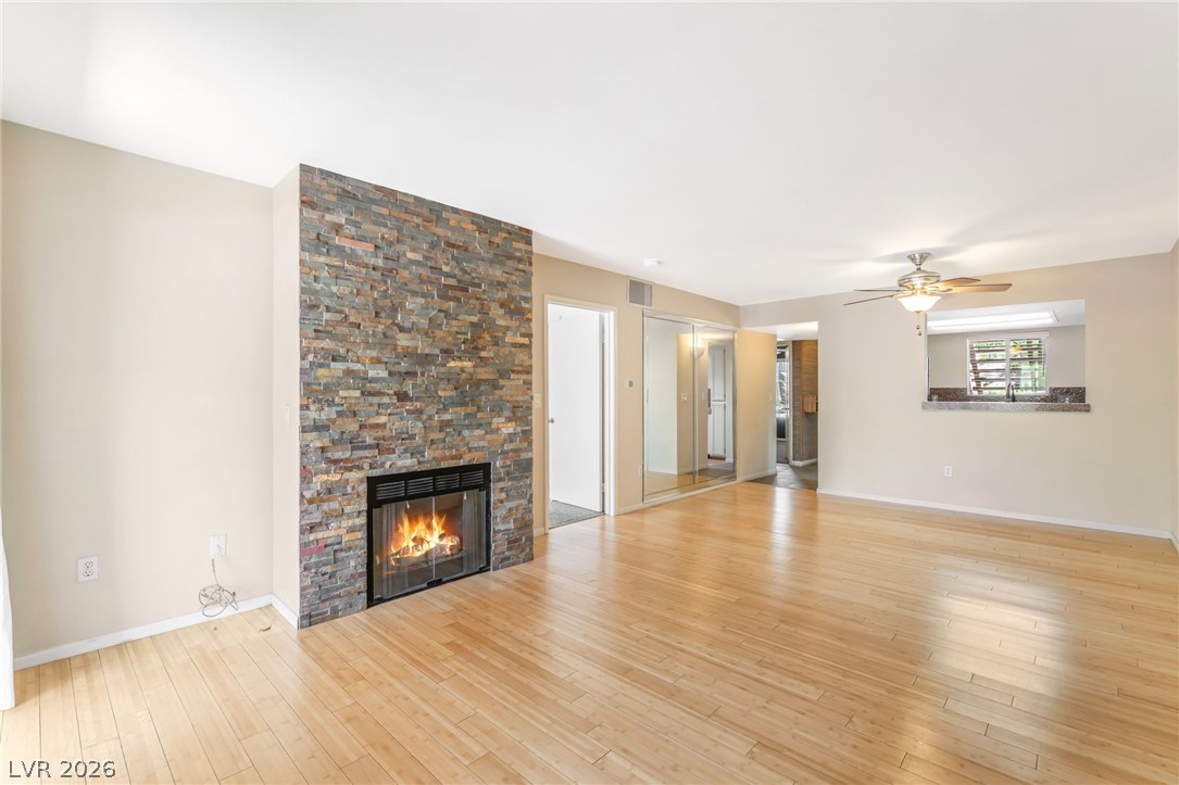 1901 Rio Canyon Court, Unit 102 Las Vegas, NV 89128 - Photo 10 of 23 A welcoming living room featuring warm hardwood flooring and a stacked stone fireplace.