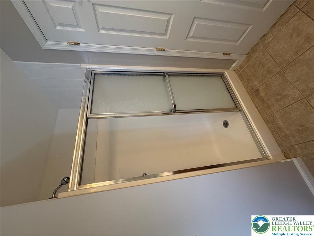4157 Walter Road Bethlehem, PA 18020 - Photo 18 of 36 A well-maintained shower with sliding glass doors and tiled flooring offers practicality.