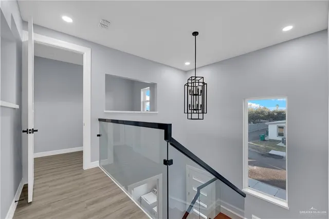 a view of a hallway with wooden floor and staircase