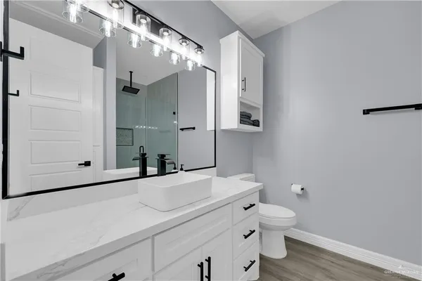 a bathroom with a sink a toilet and shower