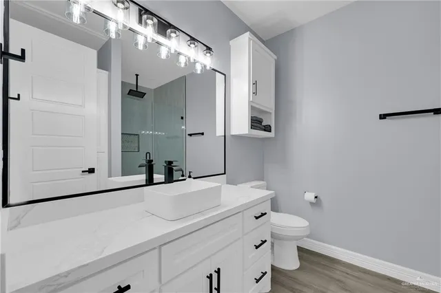 a bathroom with a sink a toilet and shower