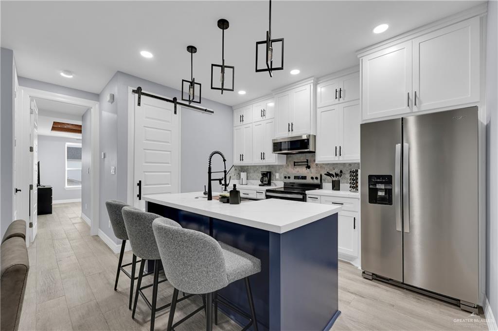 600 West Seminole Avenue Pharr, TX 78577 - Photo 3 of 17 a kitchen with stainless steel appliances a sink a stove a refrigerator a center island and chairs