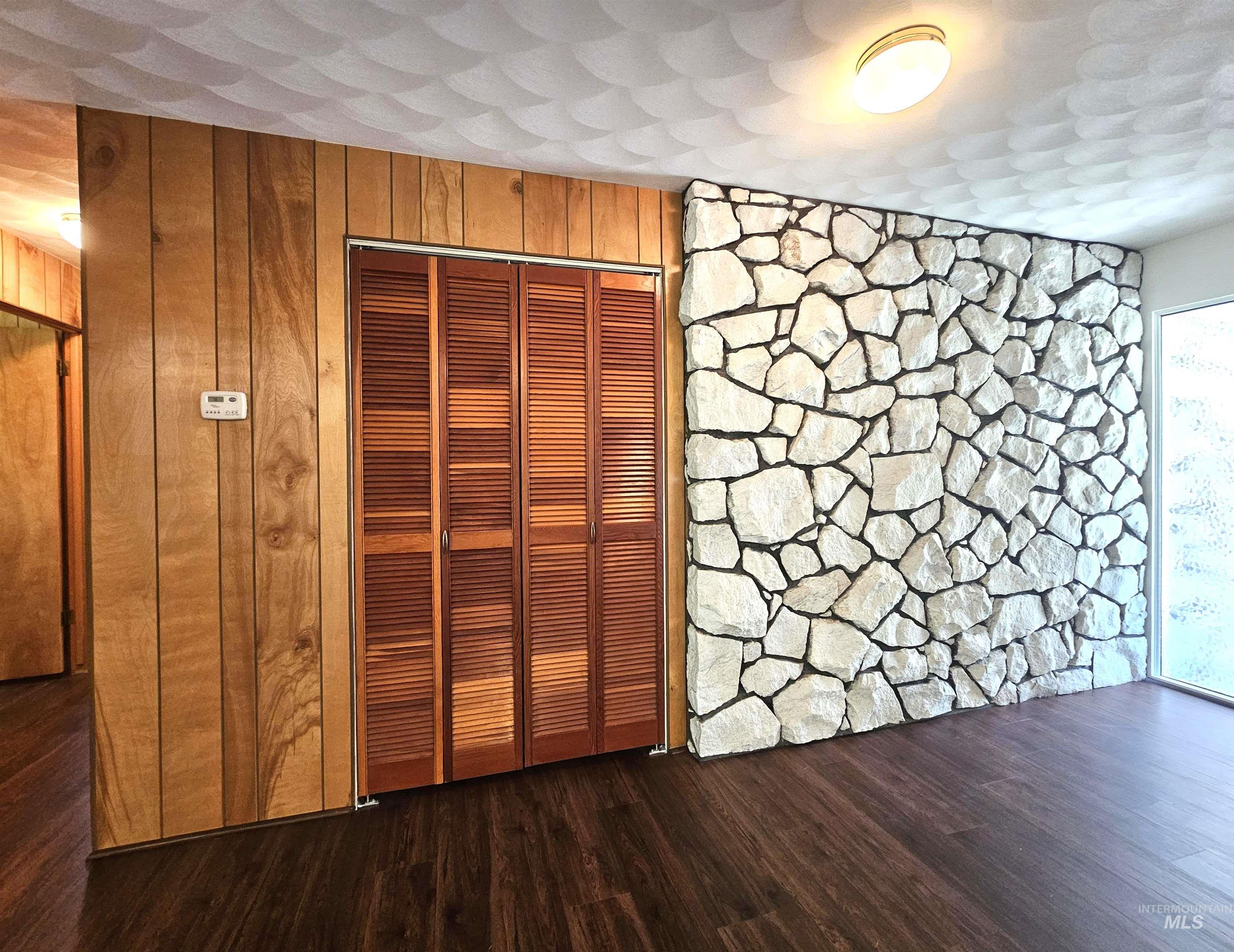 29865 Mission Creek Road Culdesac, ID 83524 - Photo 3 of 43 Feature stone accent wall, wood-finish flooring, and wood paneling