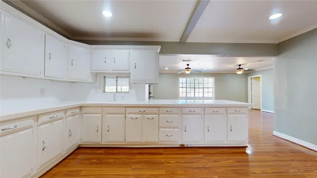 a view of a room with wooden floor and a ceiling fan