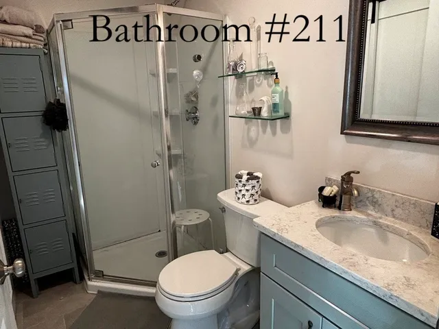 a bathroom with a granite countertop sink toilet and shower