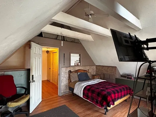 a bed sitting in a bedroom next to a small window