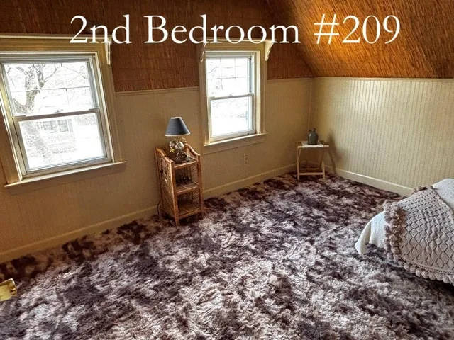 a bedroom with a bed and a refrigerator