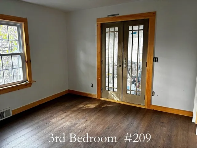 an empty room with wooden floor and closet